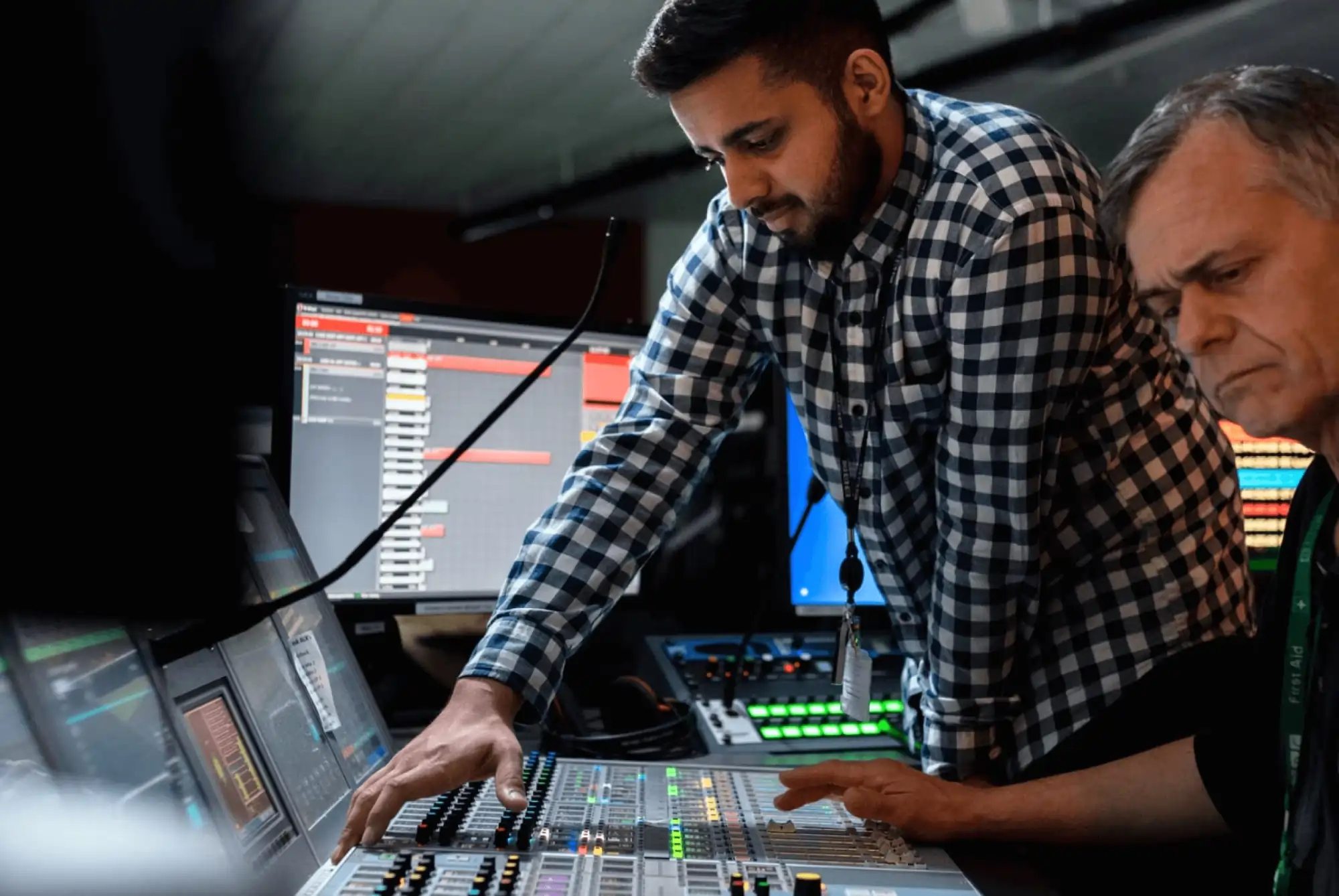 two men broadcasting radio in a professional studio with a mixing desk